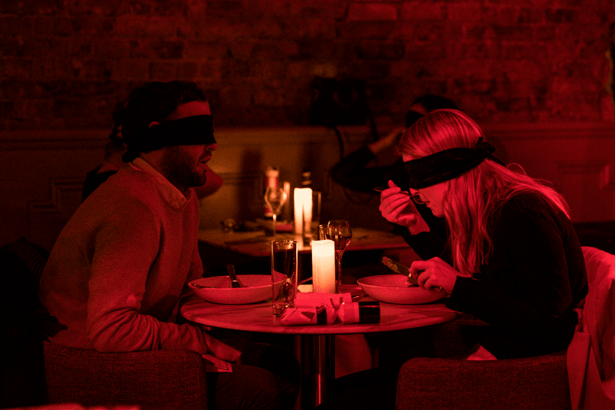 Una coppia bendata che cena a "Dining in the Dark".